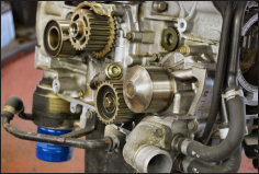 A Subaru boxer engine stripped down on the bench, timing gears exposed